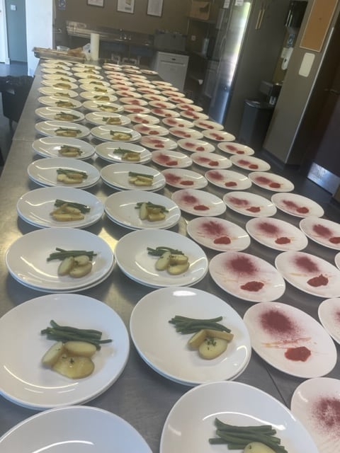 A long table of plated courses prepared for an event service